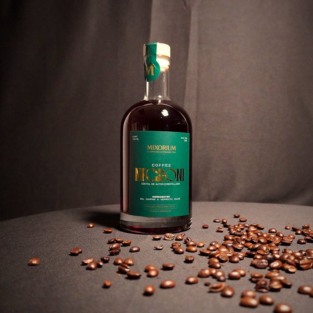 Botella de Coffee Negroni rodeada de granos de café tostado