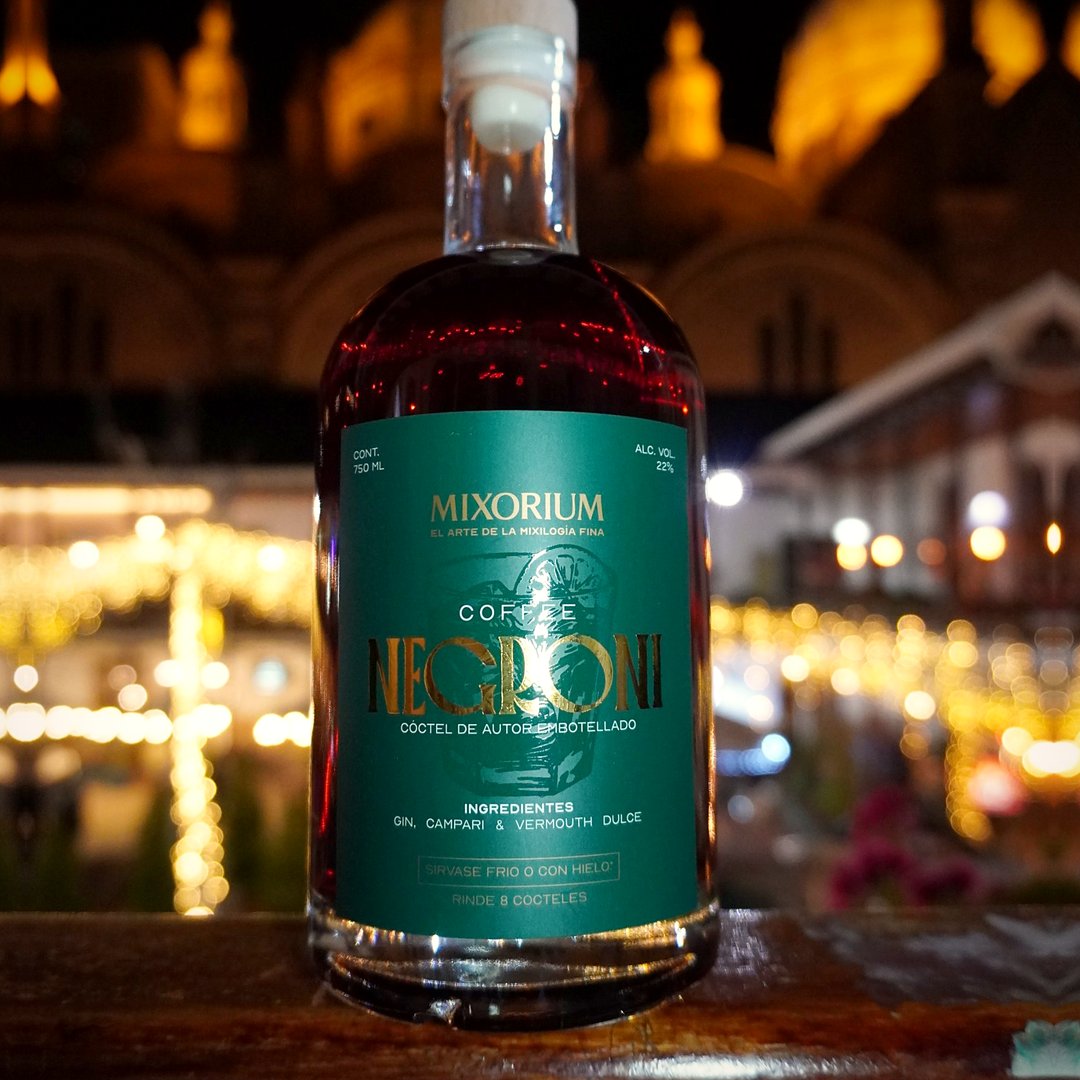 Botella de Coffee Negroni de 750 ml de noche, con luces cálidas de fondo